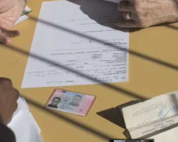 Photo montrant des papiers et des mains sur une table extraite du film réalisé en 2015 sur la Cimade